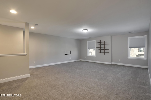 spare room with visible vents, dark carpet, and baseboards