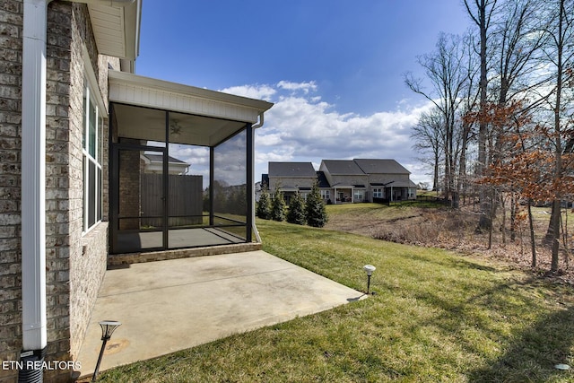 view of yard with a ceiling fan, a patio, and a sunroom