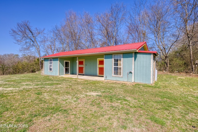 single story home featuring a patio, a front yard, and metal roof