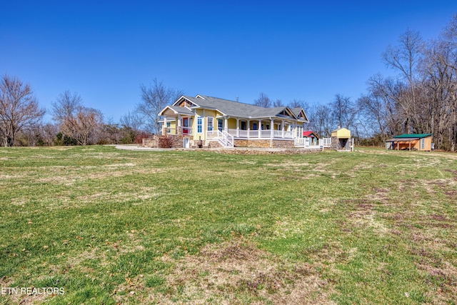 back of property with a yard and covered porch