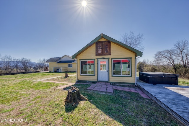 view of front facade featuring a front yard and a hot tub