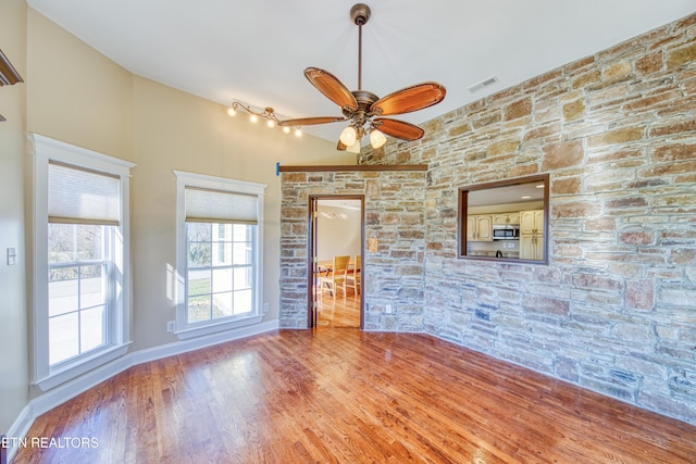 unfurnished room featuring visible vents, baseboards, wood finished floors, and a ceiling fan