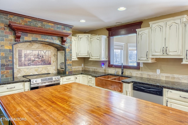 kitchen with wooden counters, recessed lighting, a sink, stainless steel appliances, and tasteful backsplash