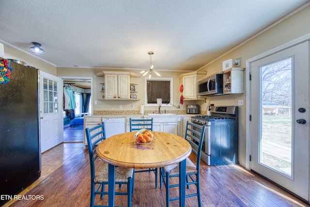 kitchen featuring wood finished floors, open shelves, a sink, light countertops, and appliances with stainless steel finishes