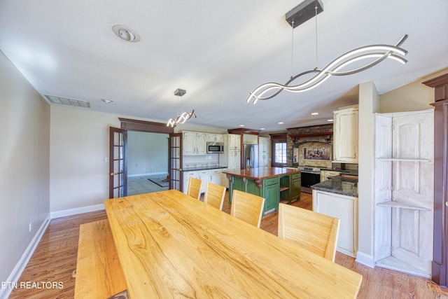 dining room with baseboards, visible vents, recessed lighting, light wood-type flooring, and a chandelier