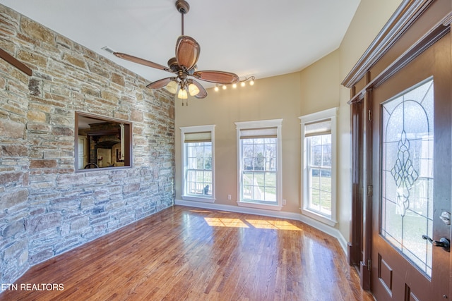 interior space with ceiling fan, baseboards, and wood finished floors