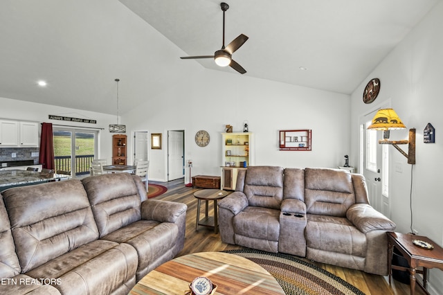 living area featuring high vaulted ceiling, ceiling fan, and dark wood-style flooring