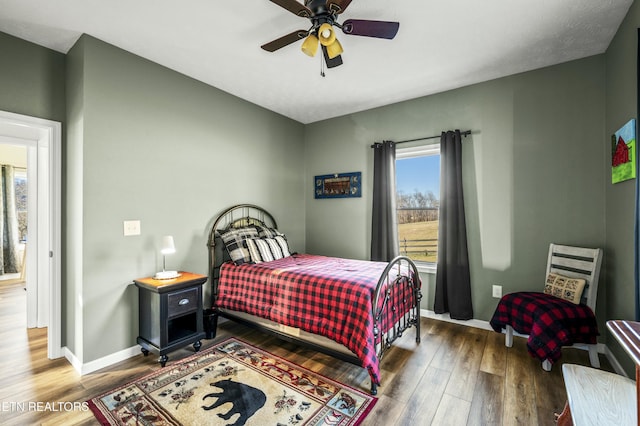 bedroom with ceiling fan, baseboards, and wood finished floors