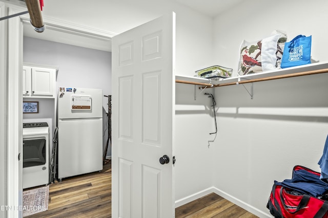 laundry area with cabinet space, washer / dryer, baseboards, and wood finished floors