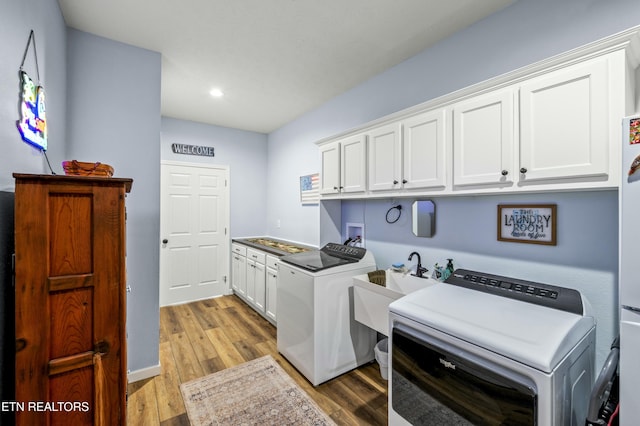 laundry room with light wood finished floors, recessed lighting, cabinet space, and washer and clothes dryer