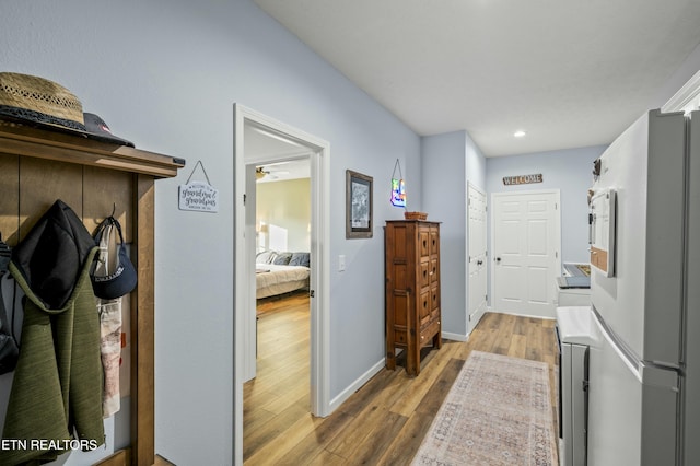 hall featuring recessed lighting, wood finished floors, and baseboards