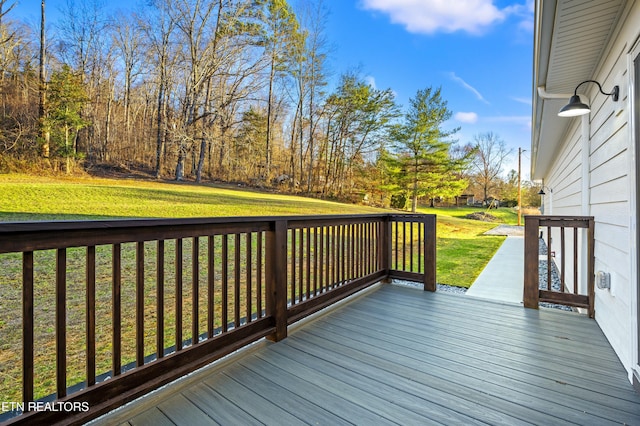 wooden terrace featuring a lawn