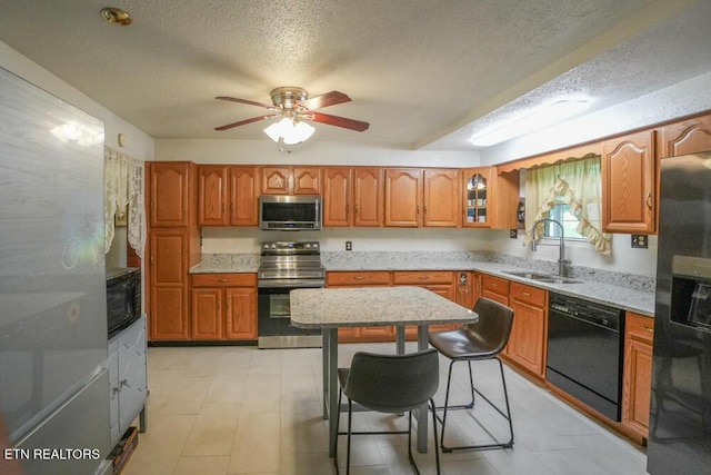 1301 Chert Pit Rd, Knoxville, TN 37923 - kitchen with black appliances, brown cabinets, a textured ceiling, a ceiling fan, and a kitchen bar
