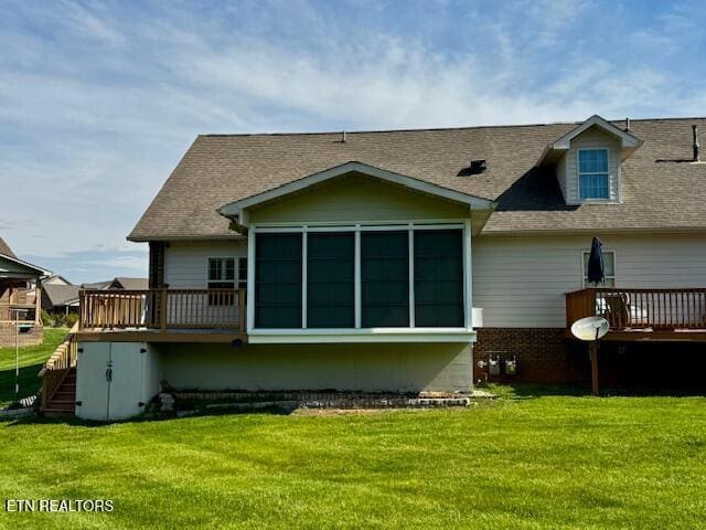 back of property featuring a wooden deck, a yard, and a shingled roof