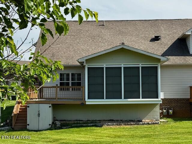 back of property featuring stairs, roof with shingles, a yard, a sunroom, and a wooden deck