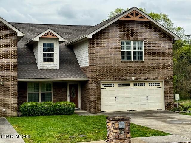 view of front of house with driveway, a front lawn, a garage, roof with shingles, and brick siding