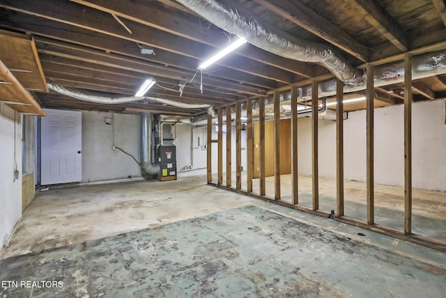 unfinished basement featuring heating unit