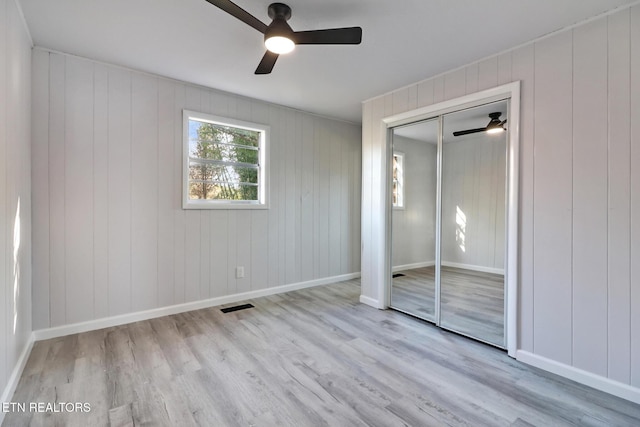 unfurnished bedroom with visible vents, baseboards, wood finished floors, and a ceiling fan