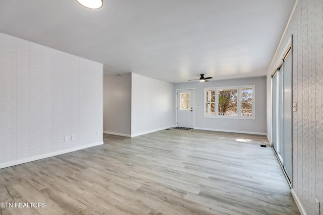 empty room featuring baseboards, a ceiling fan, and wood finished floors