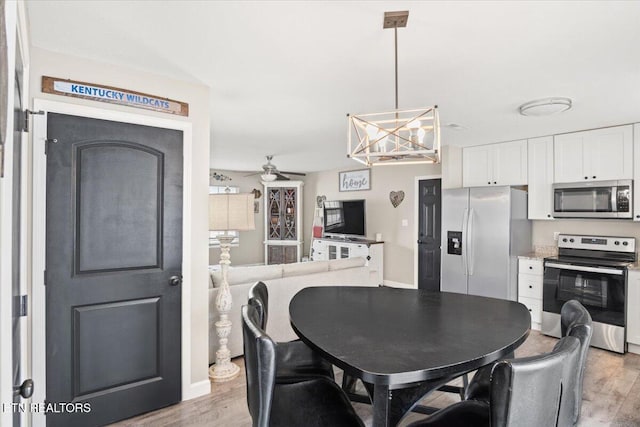 dining area with light wood-type flooring and ceiling fan