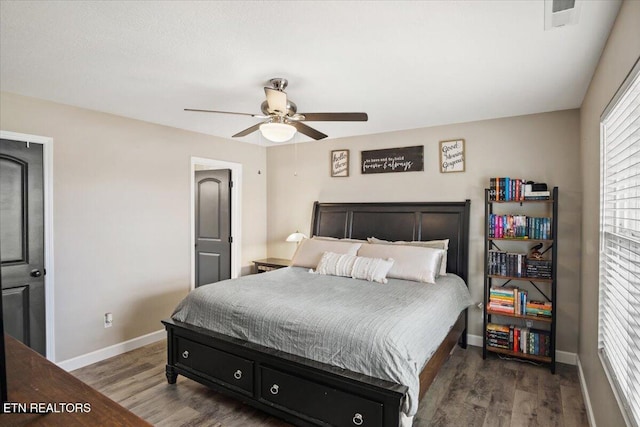 bedroom featuring visible vents, a ceiling fan, baseboards, and wood finished floors