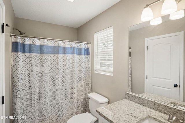 bathroom with vanity, a shower with shower curtain, and toilet