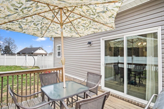 deck featuring outdoor dining space and fence