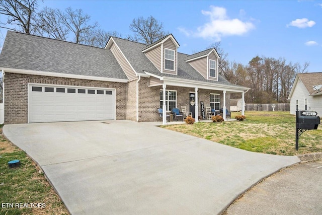 cape cod-style house with covered porch, concrete driveway, a front yard, an attached garage, and brick siding