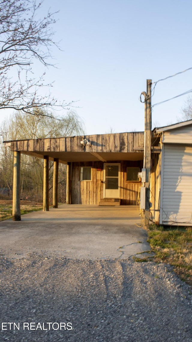 view of front facade featuring aphalt driveway and a carport