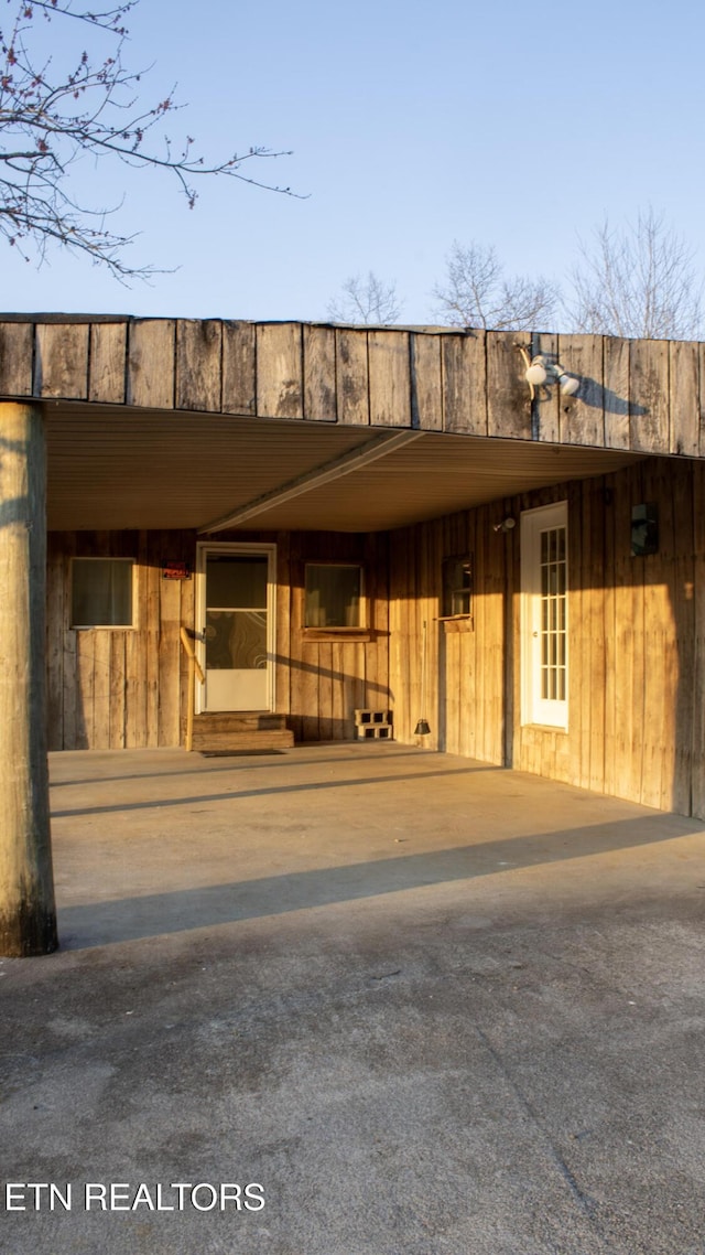 doorway to property featuring an attached carport