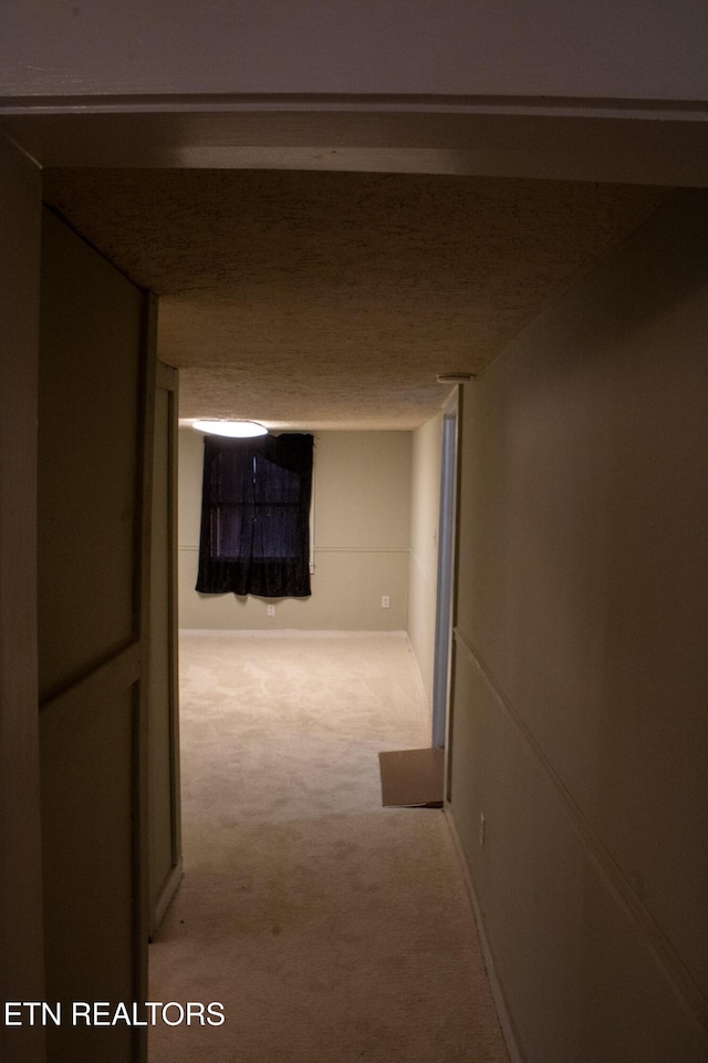 hallway with carpet flooring and baseboards