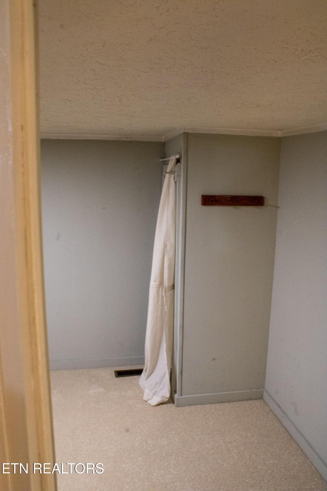 bathroom featuring visible vents, a textured ceiling, and baseboards