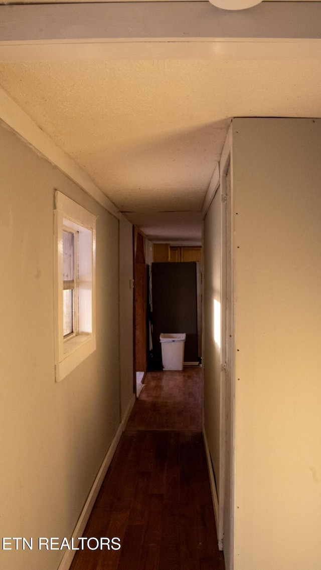 hallway with baseboards and dark wood-style floors