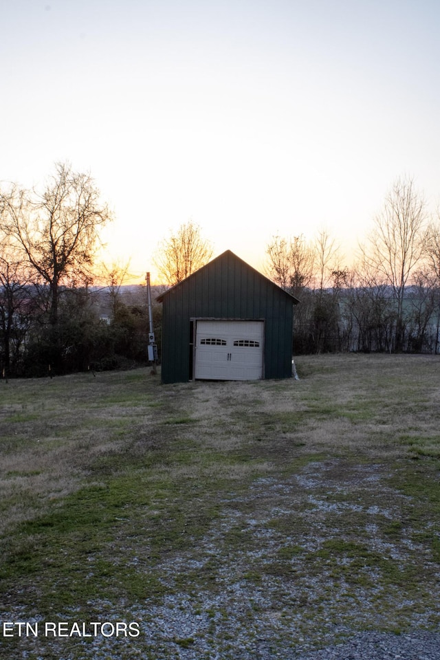 yard at dusk with an outbuilding and a detached garage