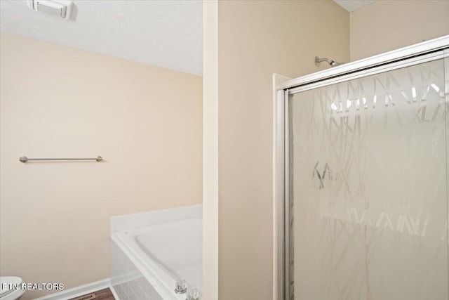 full bathroom featuring baseboards, visible vents, a shower stall, a textured ceiling, and a garden tub