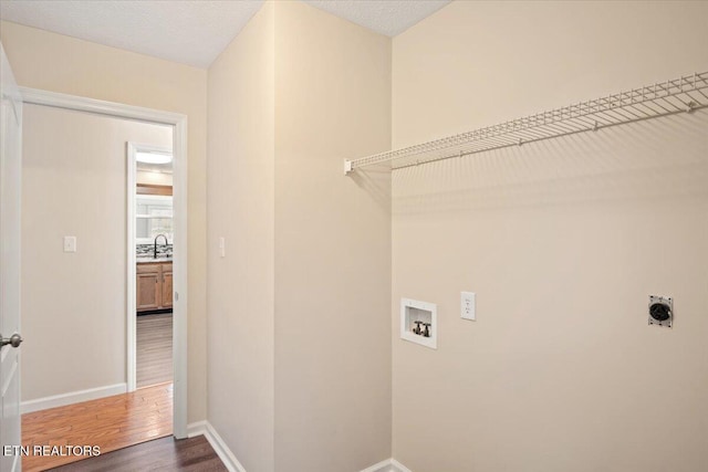 laundry room featuring wood finished floors, baseboards, laundry area, electric dryer hookup, and washer hookup