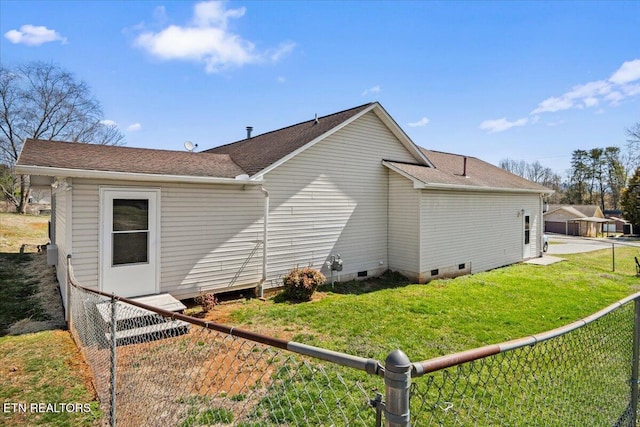 back of property with crawl space, a lawn, a fenced backyard, and a shingled roof