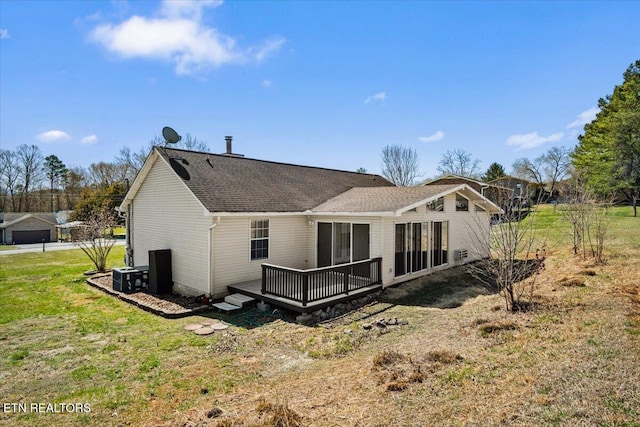 rear view of property with a yard, central air condition unit, a wooden deck, and roof with shingles