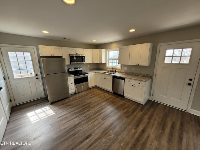 kitchen featuring a sink, appliances with stainless steel finishes, dark wood finished floors, and white cabinets