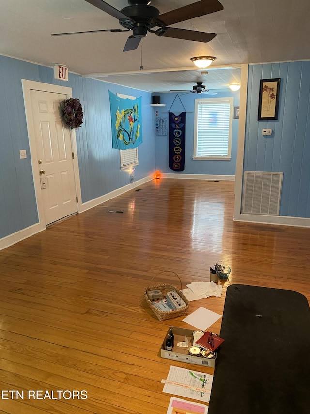 unfurnished living room featuring ceiling fan, wood finished floors, visible vents, and baseboards