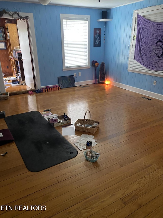 interior space featuring visible vents, baseboards, and wood finished floors