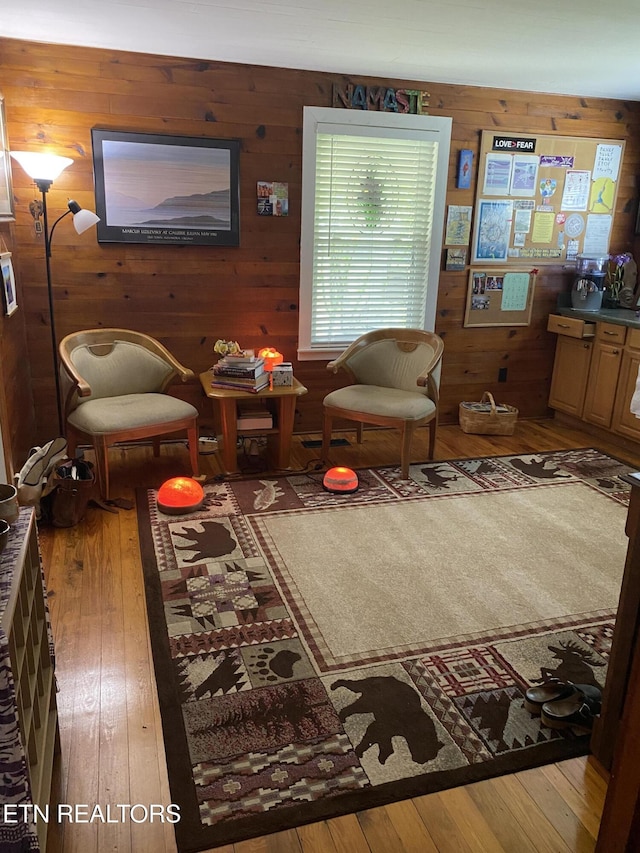 living area featuring wood walls and hardwood / wood-style flooring