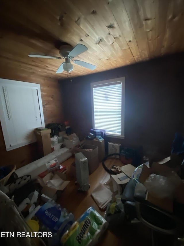 bedroom with wood walls, wood ceiling, ceiling fan, and wood finished floors