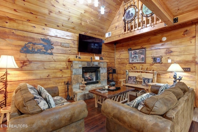 living area featuring wooden walls, wood finished floors, visible vents, a stone fireplace, and wooden ceiling