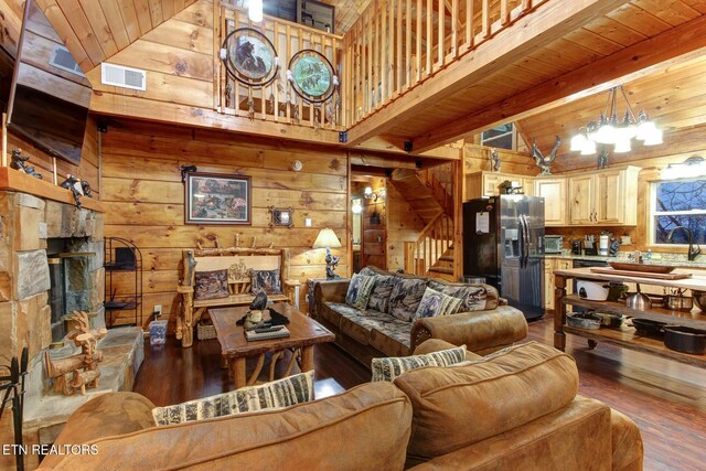 living area featuring wooden ceiling, visible vents, and wood walls