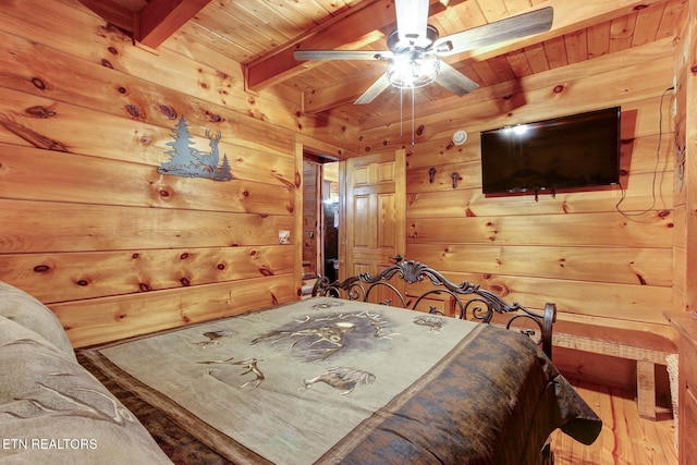 bedroom with wood finished floors, beamed ceiling, wood ceiling, and wood walls