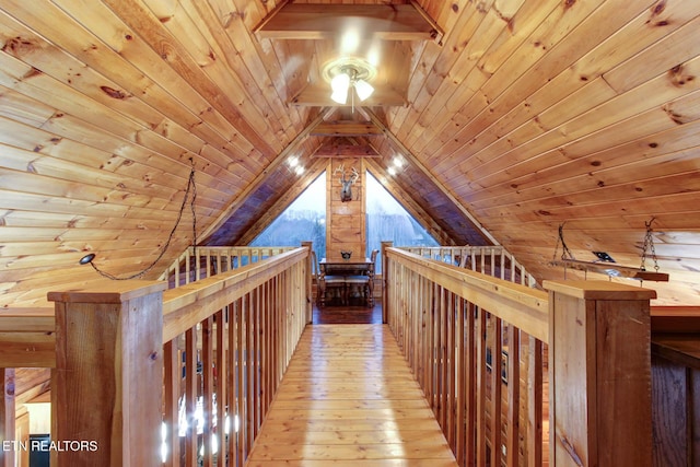 corridor with wooden ceiling, light wood-style flooring, an upstairs landing, and lofted ceiling