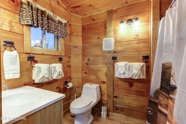 full bathroom with wooden walls, vanity, and toilet