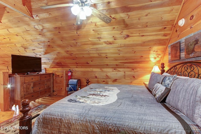 bedroom featuring wood finished floors and wood walls