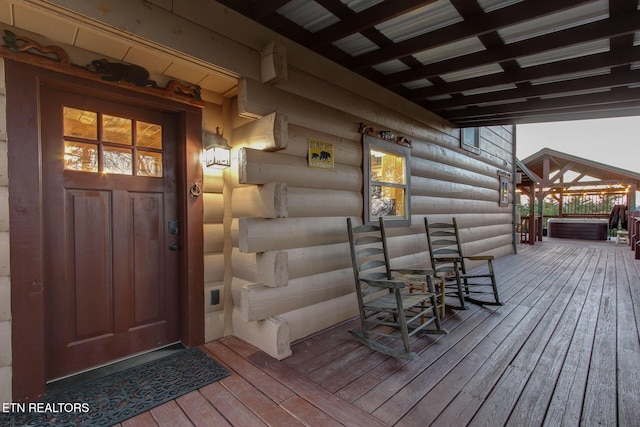 wooden terrace featuring a hot tub